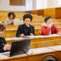 Kelompok mahasiswa belajar bersama dengan laptop sebagai simbol evaluasi kinerja dan peningkatan berkelanjutan ISO 21001