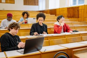 Kelompok mahasiswa belajar bersama dengan laptop sebagai simbol evaluasi kinerja dan peningkatan berkelanjutan ISO 21001