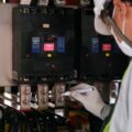 Teknisi memeriksa panel listrik dan konsumsi energi