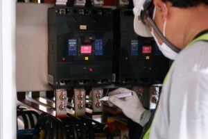 Teknisi memeriksa panel listrik dan konsumsi energi