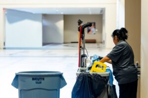 Petugas kebersihan dengan peralatan cleaning sebagai ilustrasi layanan outsourcing facility management