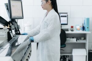 Praktisi medis berdiri di depan monitor laboratorium sebagai simbol sistem manajemen mutu alat kesehatan ISO 13485