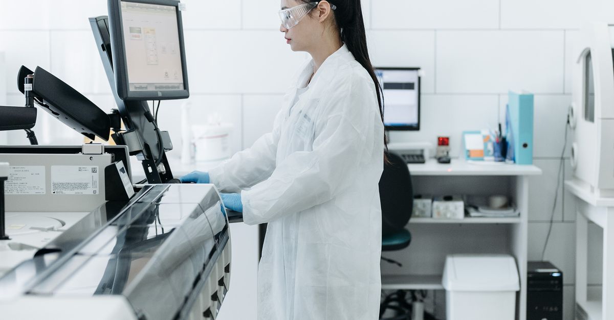 Praktisi medis berdiri di depan monitor laboratorium sebagai simbol sistem manajemen mutu alat kesehatan ISO 13485