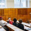 Mahasiswa berdiskusi dengan dosen di kelas sebagai simbol perencanaan dan dukungan kompetensi ISO 21001