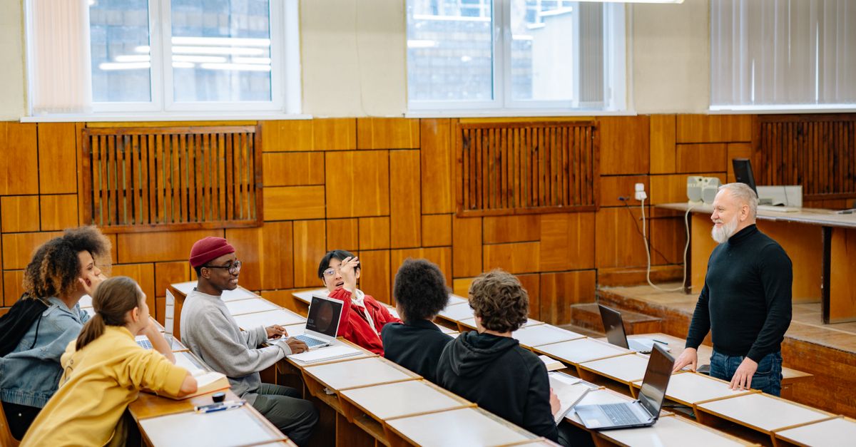 Mahasiswa berdiskusi dengan dosen di kelas sebagai simbol perencanaan dan dukungan kompetensi ISO 21001