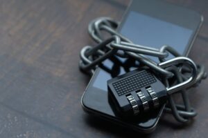 Smartphone dengan gembok sebagai simbol keamanan data