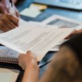 Dua profesional meninjau dokumen perbandingan klausul ISO 37001