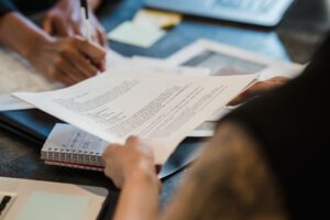Dua profesional meninjau dokumen perbandingan klausul ISO 37001